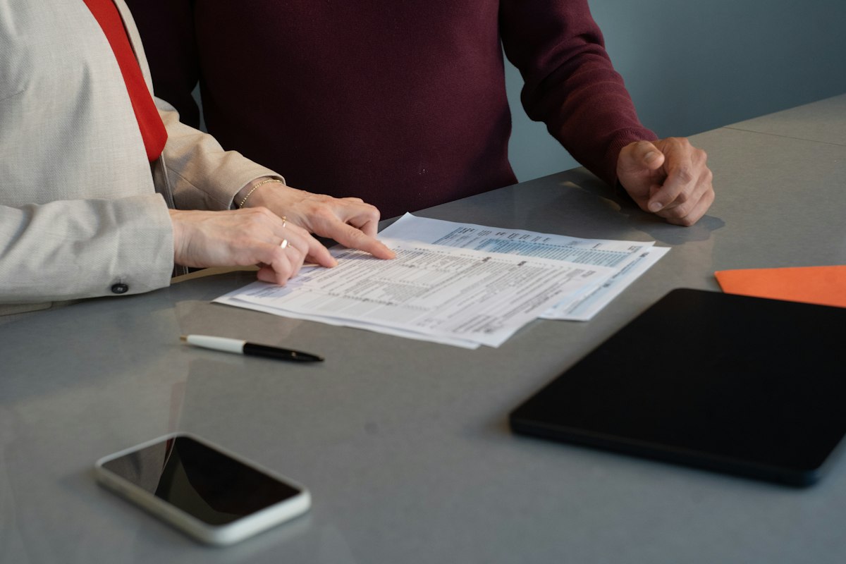 Two professionals review paperwork at a table in San Francisco. Reference photograph, not participants in Nigeria's policy consultation.