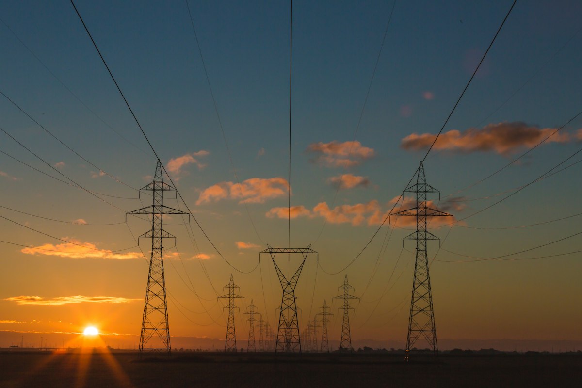 Reference photo: electricity transmission pylons at sunset; not a photograph of Transcorp facilities or the reported event.